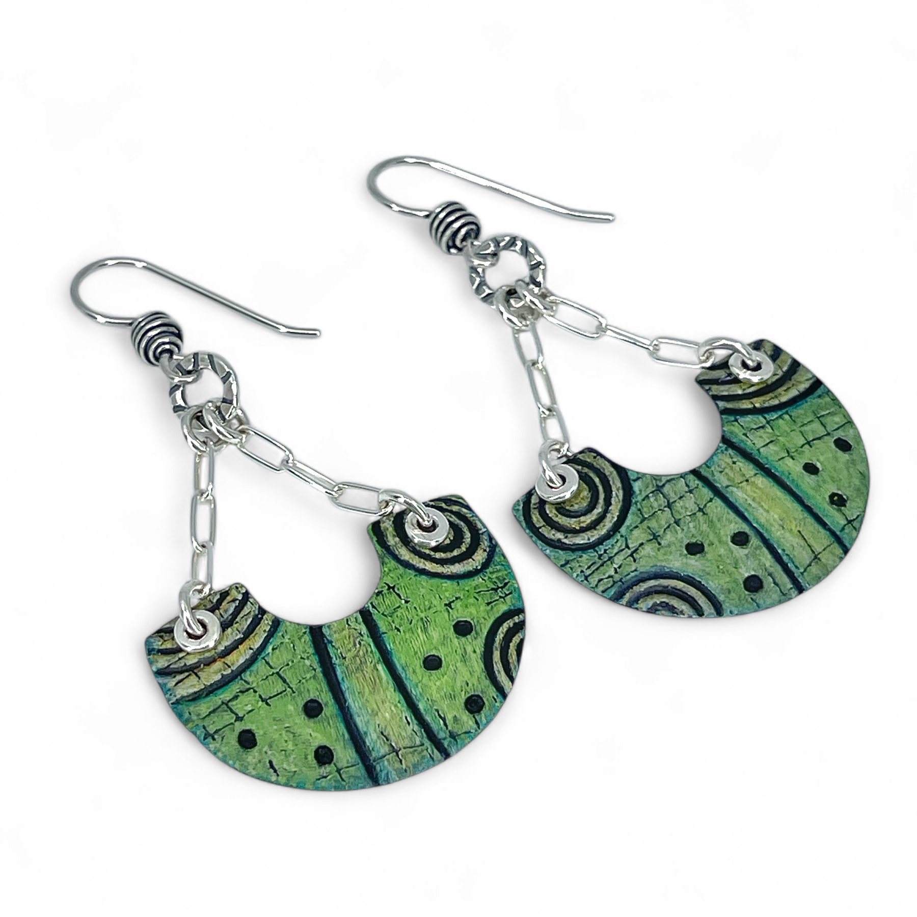 Green and black patterned earrings with silver chains on a white background