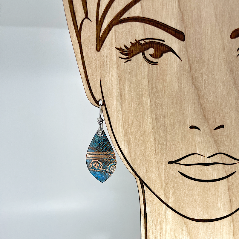 Blue copper patina earring shown on model