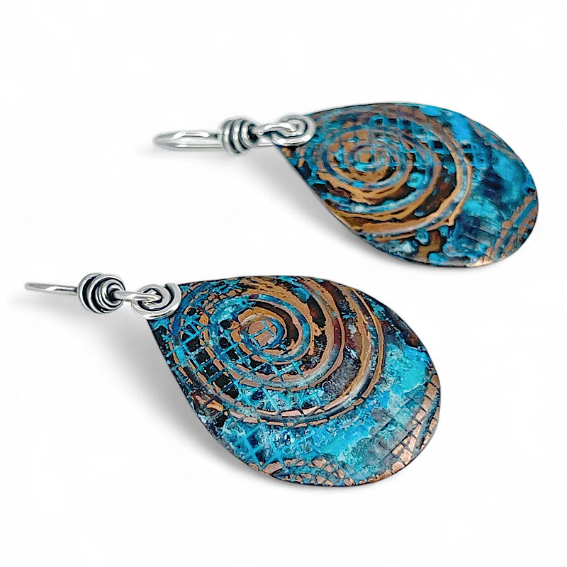 Teardrop-shaped earrings with blue and brown spiral pattern on a white background