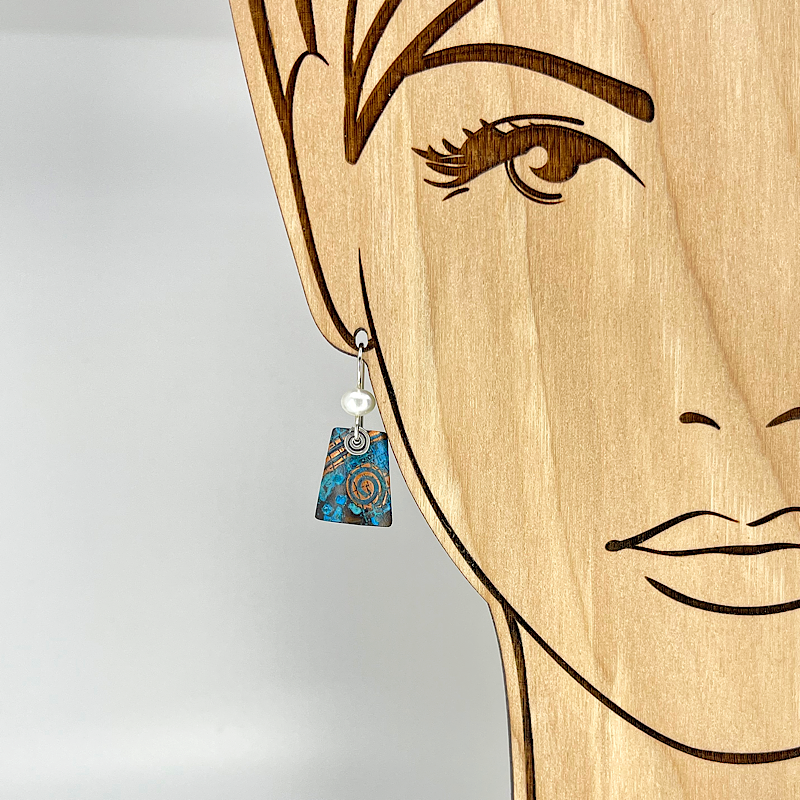 Blue copper patina earring with freshwater pearl shown on model