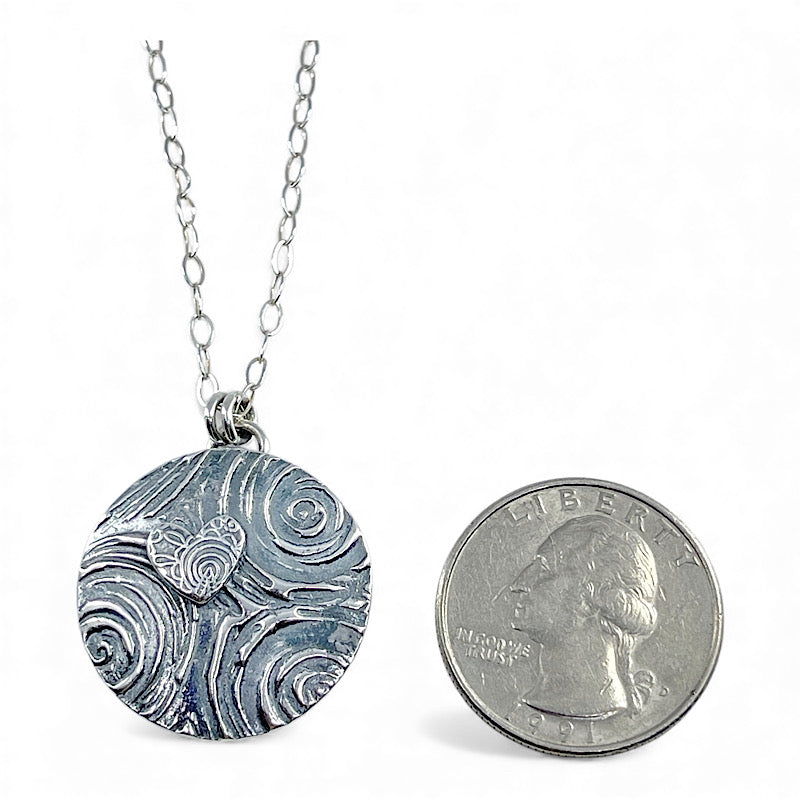 Sterling silver heart pendant, slightly larger than a quarter