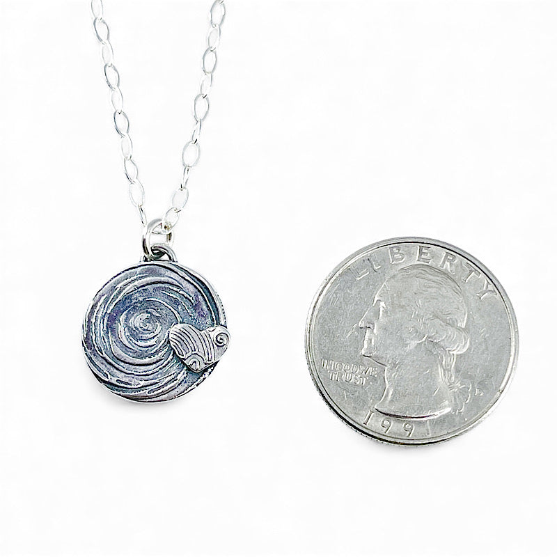 Sterling silver heart pendant shown smaller than a quarter
