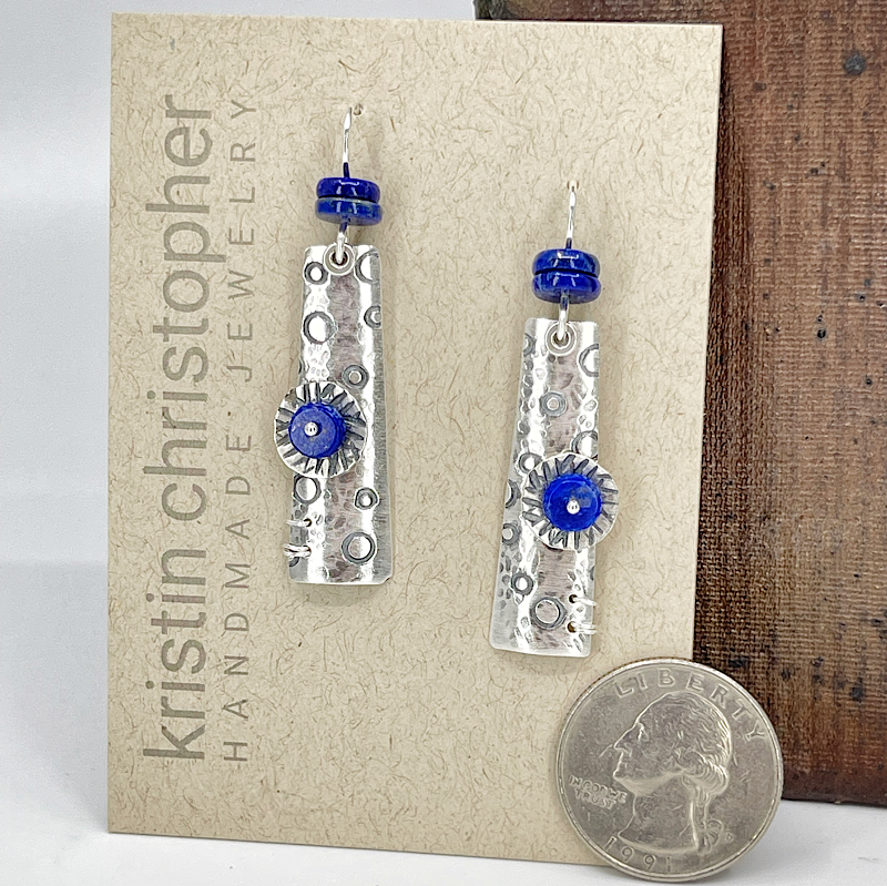 Silver earrings with blue lapis beads on a 'Kristin Christopher' jewelry card.