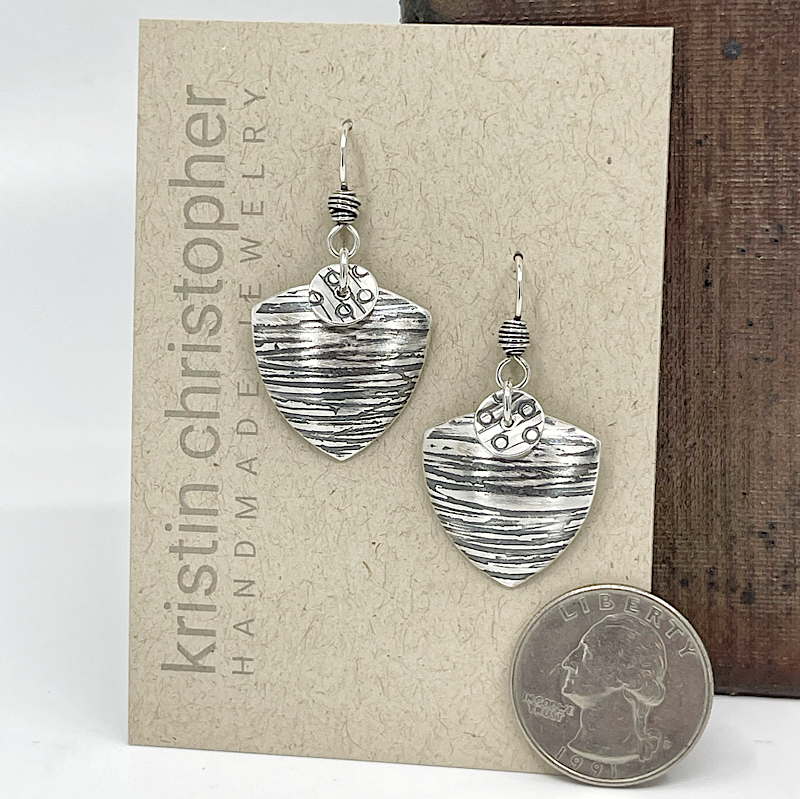 Sterling silver triangle earrings on a Kristin Christopher card by a quarter to show scale.