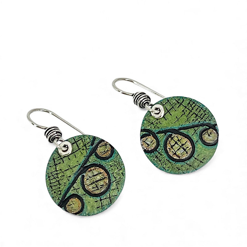 Green circular earrings with black patterns on a white background