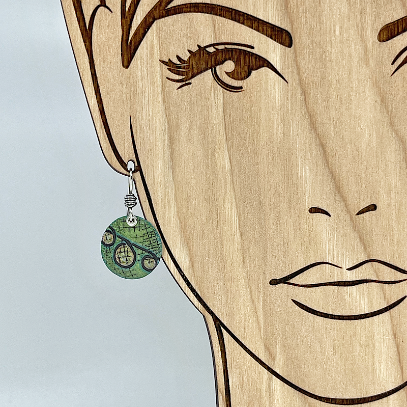 green colored earrings shown on model for scale