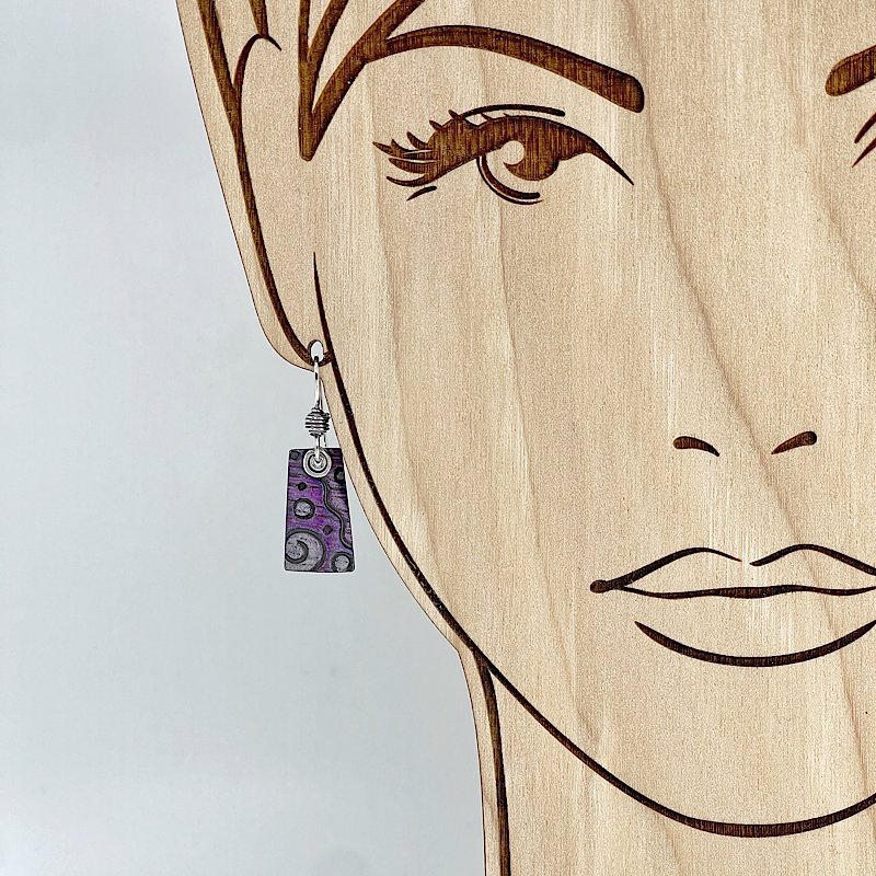 Purple and silver earrings shown on model