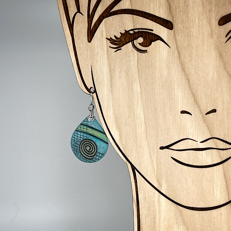 Aqua teardrop earring with spirals shown on a model