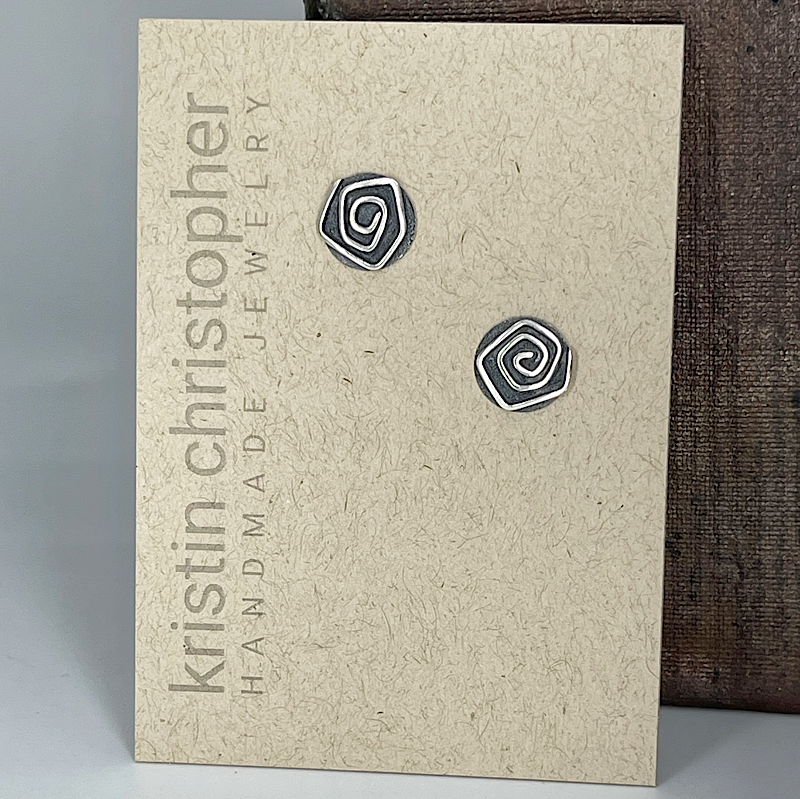 Pair of spiral-patterned sterling silver earrings on a 'Kristin Christopher Handmade Jewelry' card.