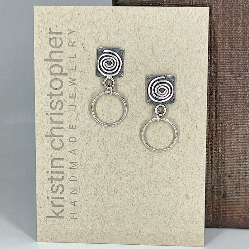 Sterling silver spiral hoop earrings on a 'Kristin Christopher' branded card.