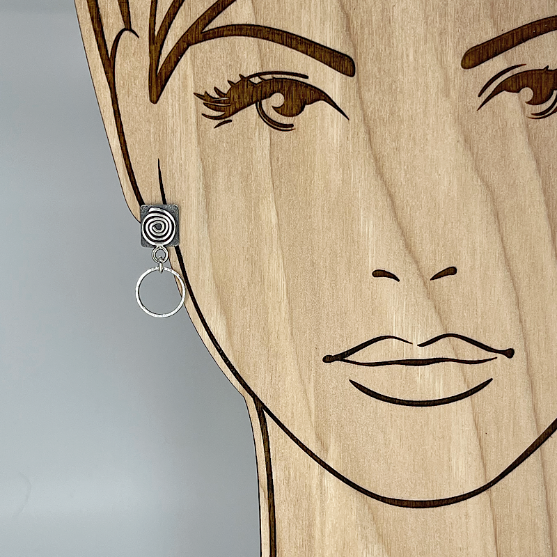 Sterling silver hoop earring with spiral shown on model