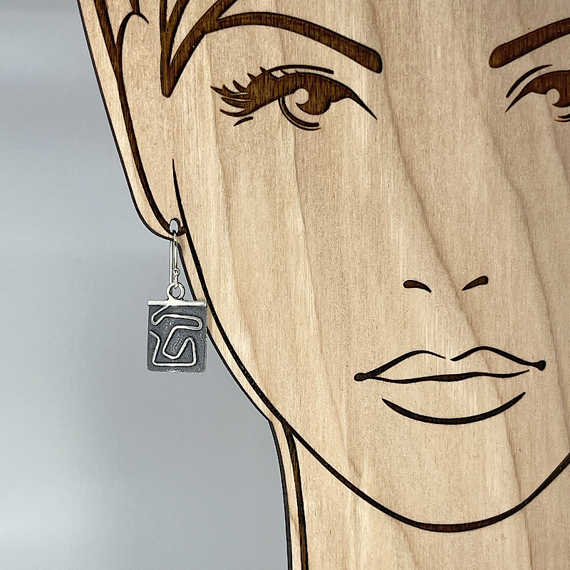 Sterling silver geometric earring show on life size model for scale