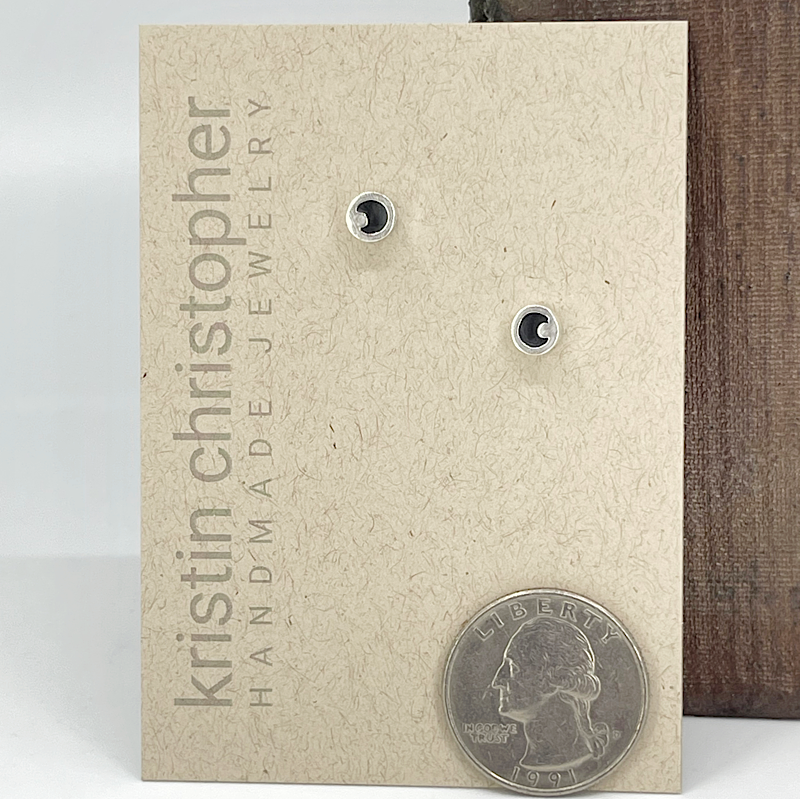 Sterling silver stud earrings on a 'Kristin Christopher' handmade jewelry card with a quarter for scale.