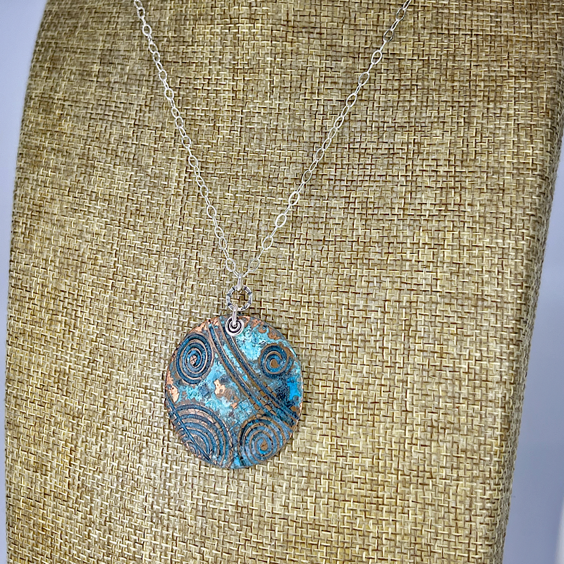 Round copper blue patina necklace shown on linen bust