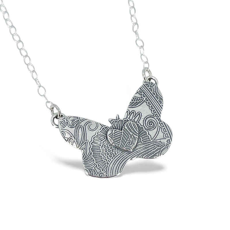Detailed sterling silver butterfly pendant with heart and oval link chain
