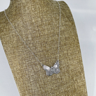Sterling silver butterfly pendant with heart shown on a linen bust