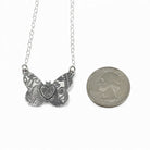 Sterling silver butterfly pendant shown next to a quarter to show comparable size