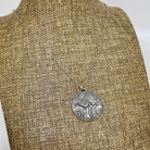 Silver heart and spirals necklac shown on a linen bust
