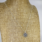 Silver flower pendant shown on linen bust