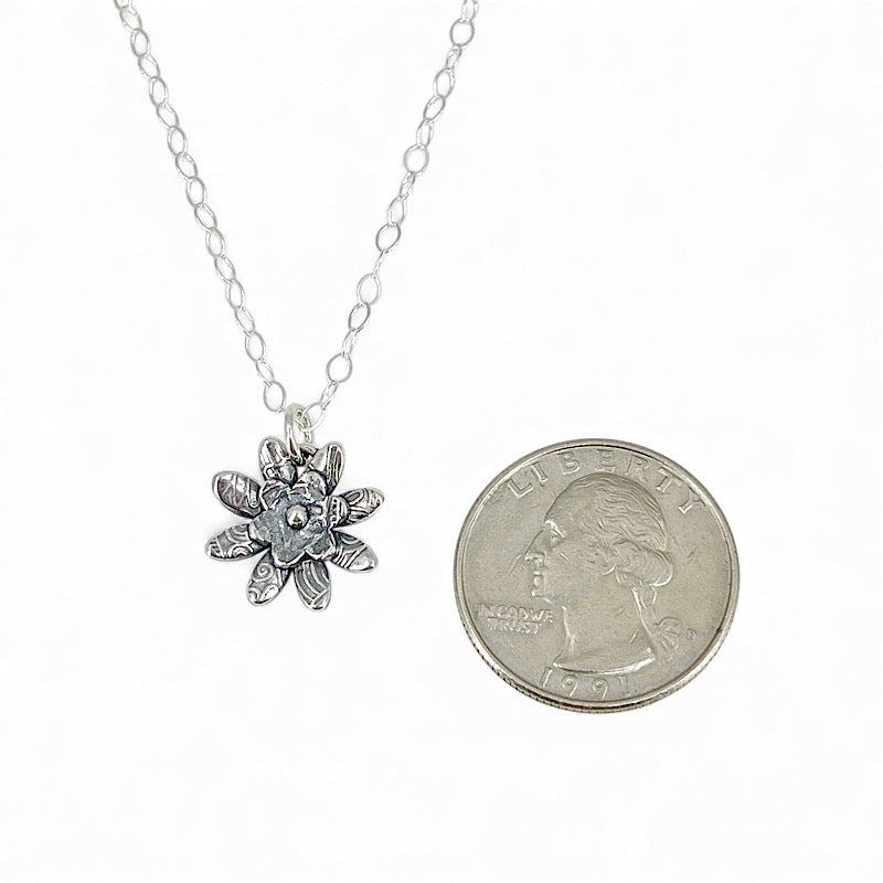 Small Sterling flower pendant shown smaller than a quarter