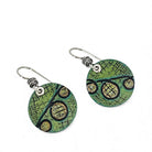 Green circular earrings with black patterns on a white background