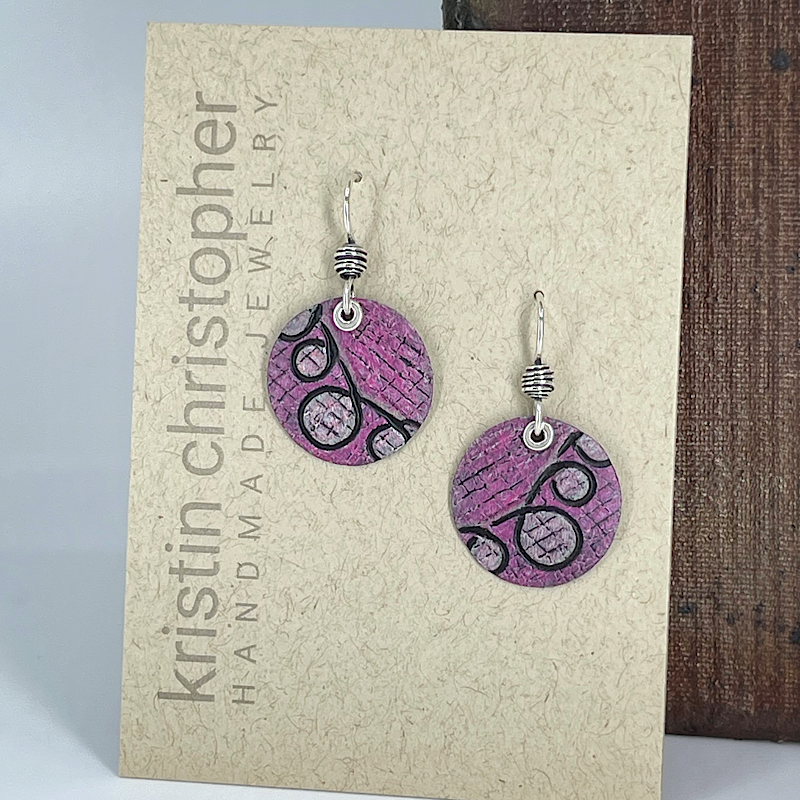 Pink circular earrings on a 'Kristin Christopher' card