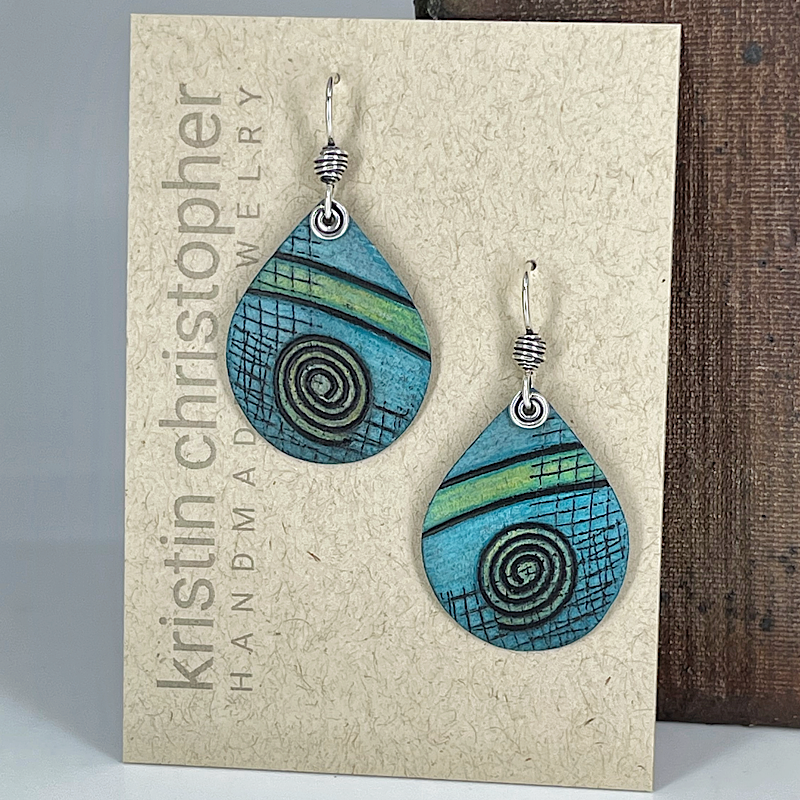 Aqua and spiral patterned earrings on a 'Kristin Christopher' card.