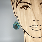 Aqua teardrop earring with spirals shown on a model