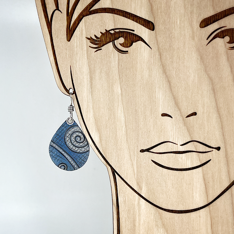 Blue earring with spiral pattern on a model