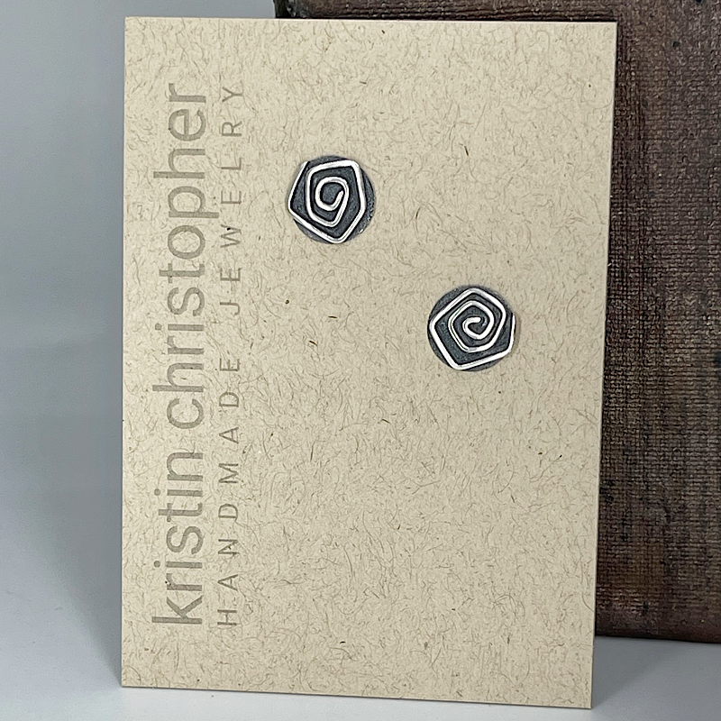 Pair of spiral-patterned sterling silver earrings on a 'Kristin Christopher Handmade Jewelry' card.