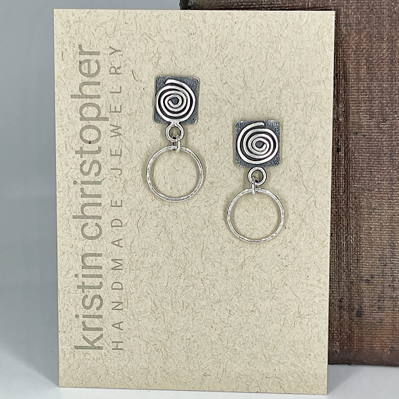 Sterling silver spiral hoop earrings on a 'Kristin Christopher' branded card.