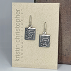 Silver earrings on a 'Kristin Christopher Handmade Jewelry' card.