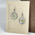 Sterling silver earrings with green peridot stones on a 'Kristin Christopher' card.
