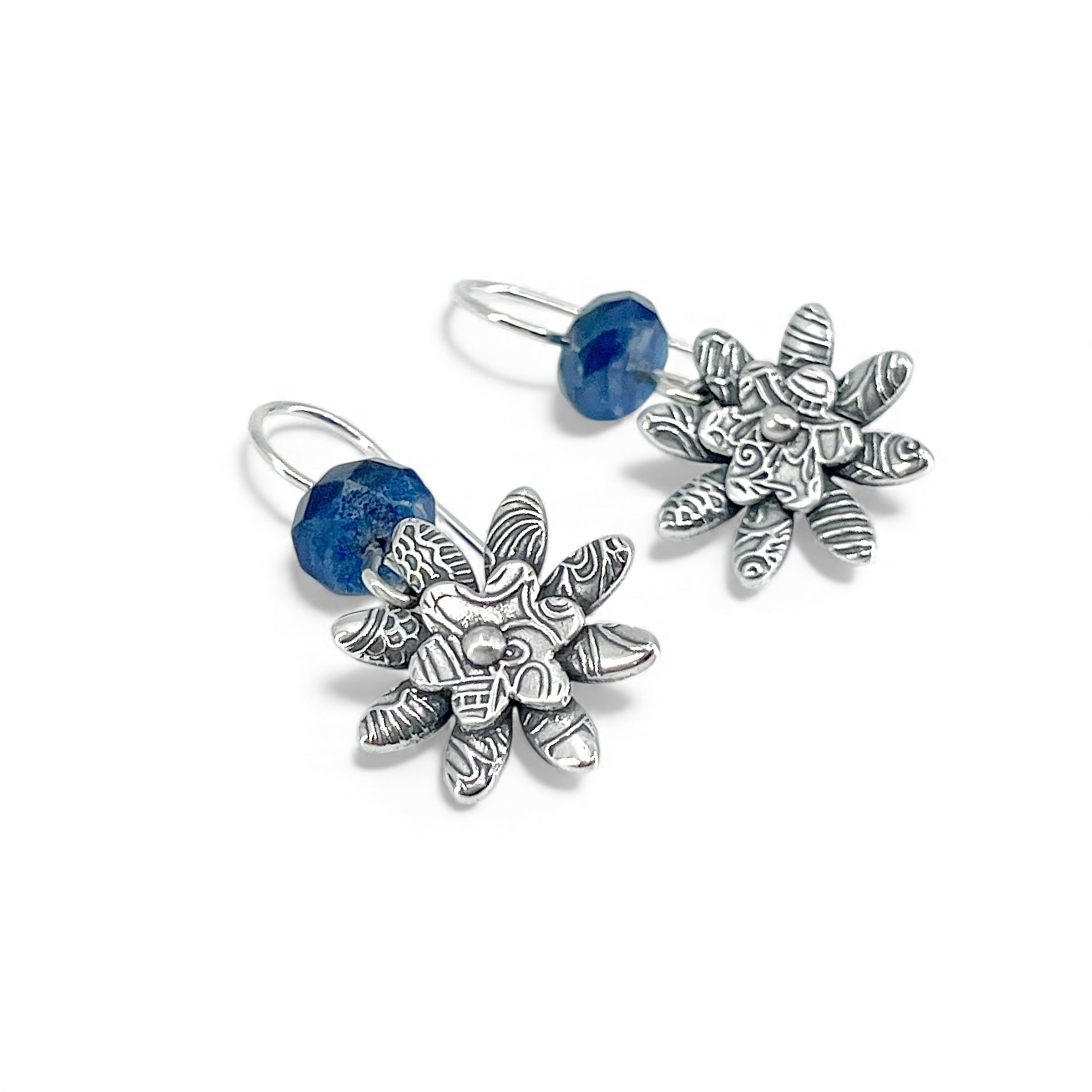 Sterling silver flower-shaped earrings with kyanite blue stones on a white background