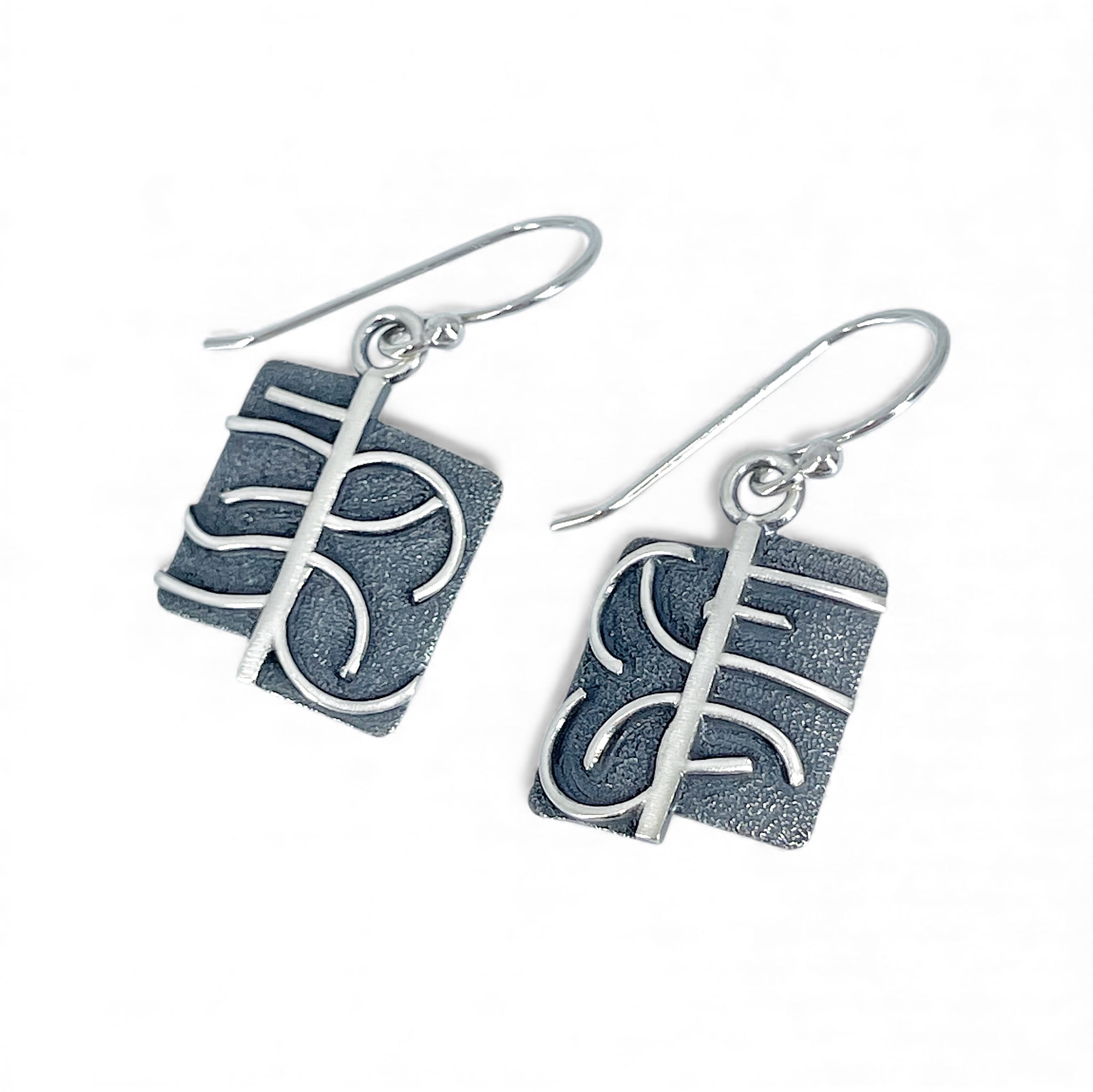Sterling silver earrings with a textured design on a white background