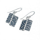 Sterling silver earrings with a textured design on a white background