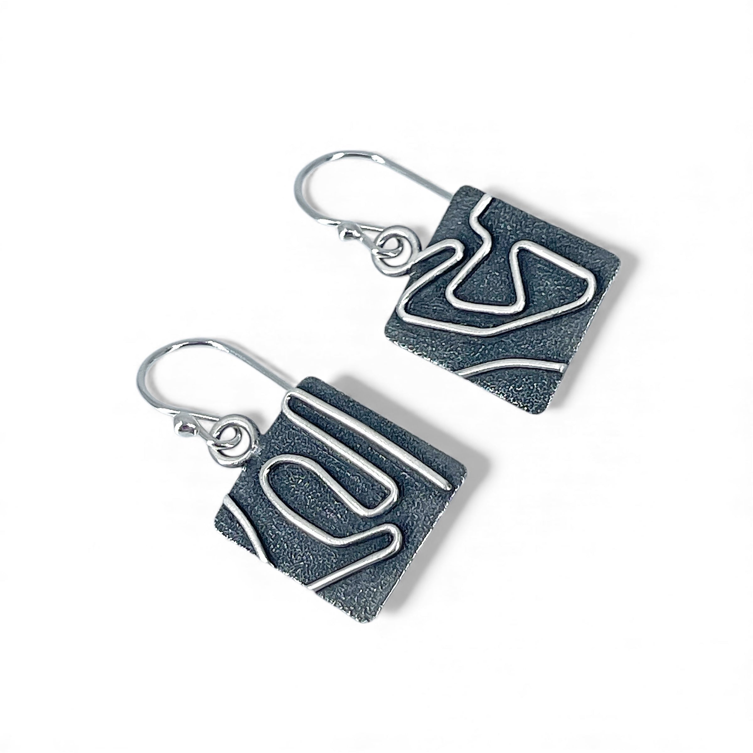 Sterling Silver earrings with geometric pattern on a white background
