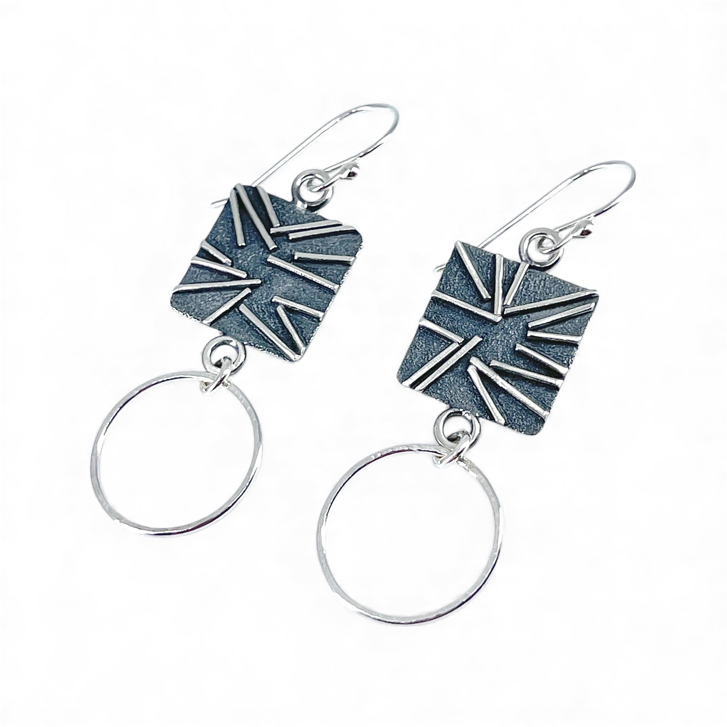Unique sterling silver earrings with geometric design and hoops on a white background